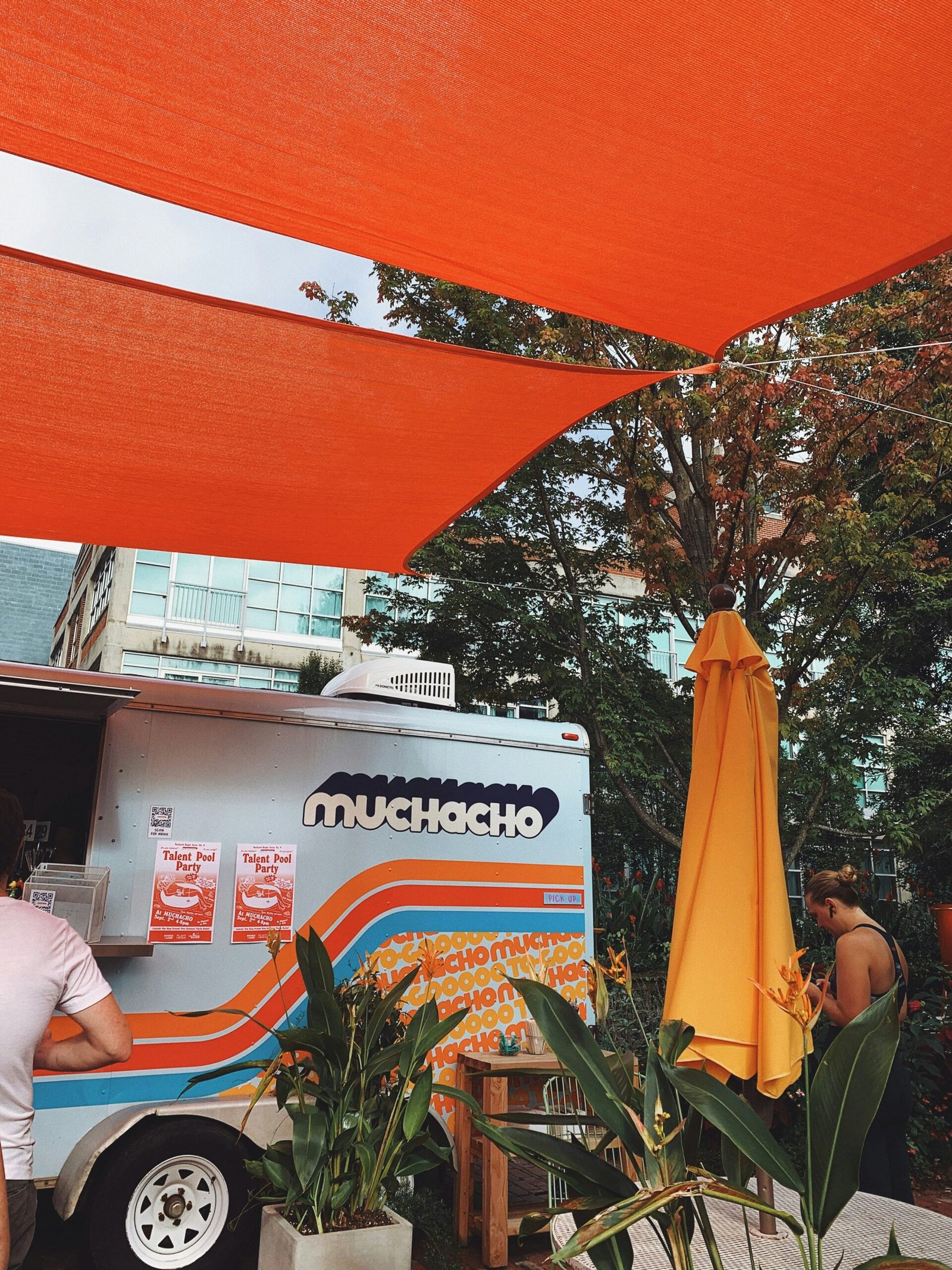 man in white t-shirt sitting on orange plastic chair